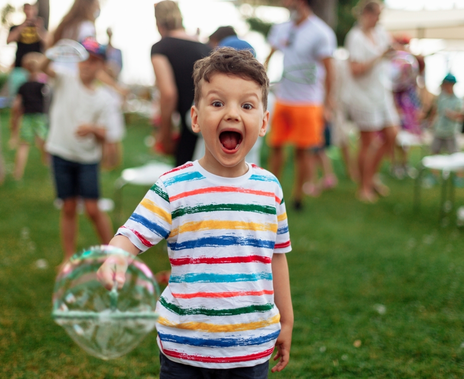 Radosny chłopczyk bawiący się bańkami mydlanymi – beztroska i dziecięca radość