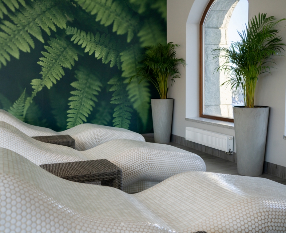 Wyprofilowane leżaki w strefie wellness w przyjaznym, relaksacyjnym wnętrzu hotelu