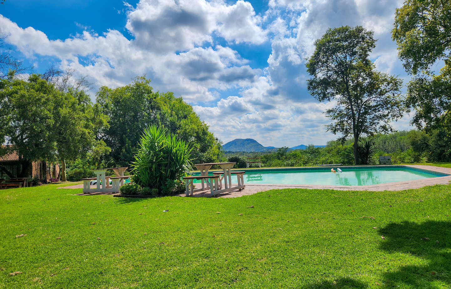 Swimming pool at The Venue Country Hotel & Spa in Hartbeespoort, with clear blue skies, landscaped gardens and a relaxing outdoor leisure setting.