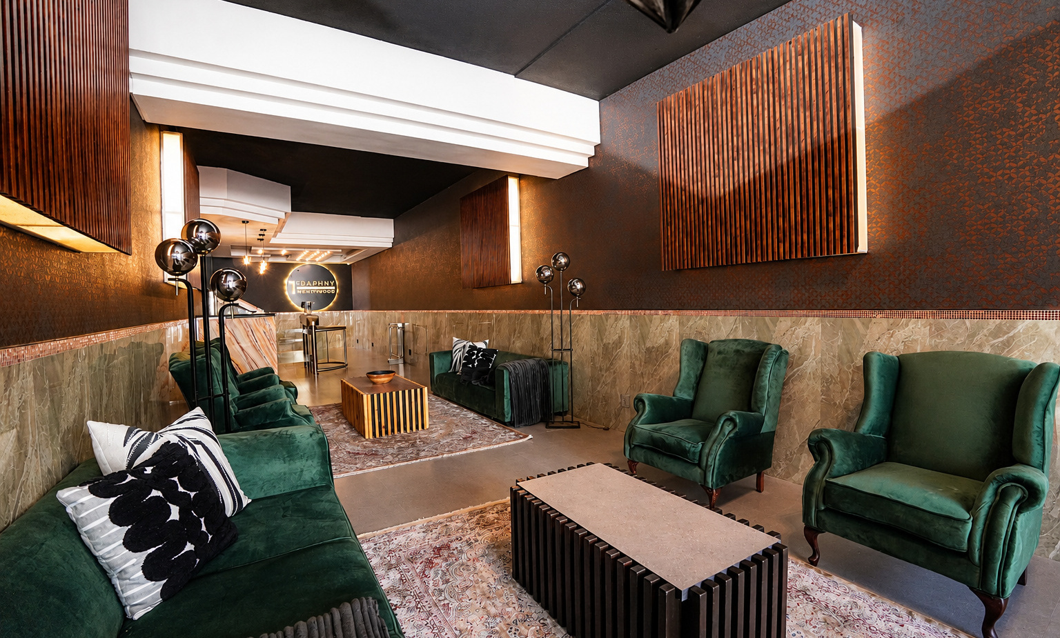 Upscale hotel lounge with emerald velvet sofas and armchairs, wooden slat wall panels, marble wainscoting, rugs and modern floor lamps