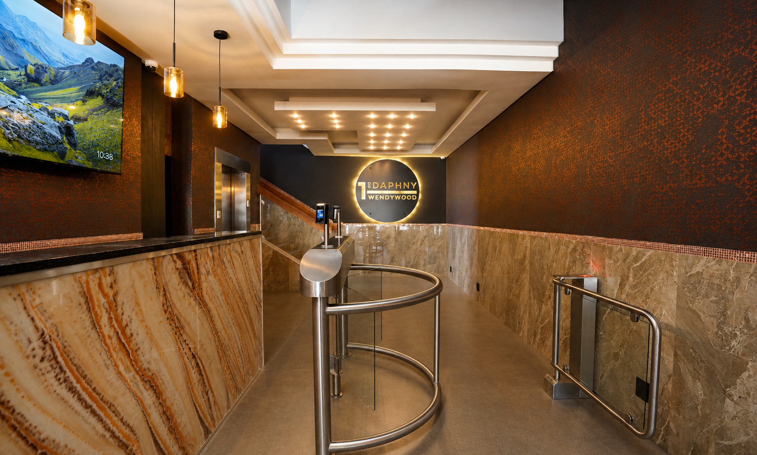 Hotel lobby with veined marble desk, warm pendant lights, stainless turnstile and backlit circular hotel logo.