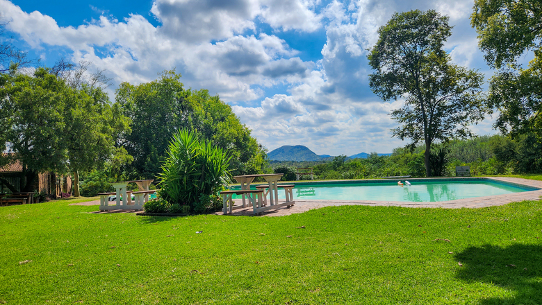Swimming pool at The Venue Country Hotel & Spa in Hartbeespoort, with clear blue skies, landscaped gardens and a relaxing outdoor leisure setting.