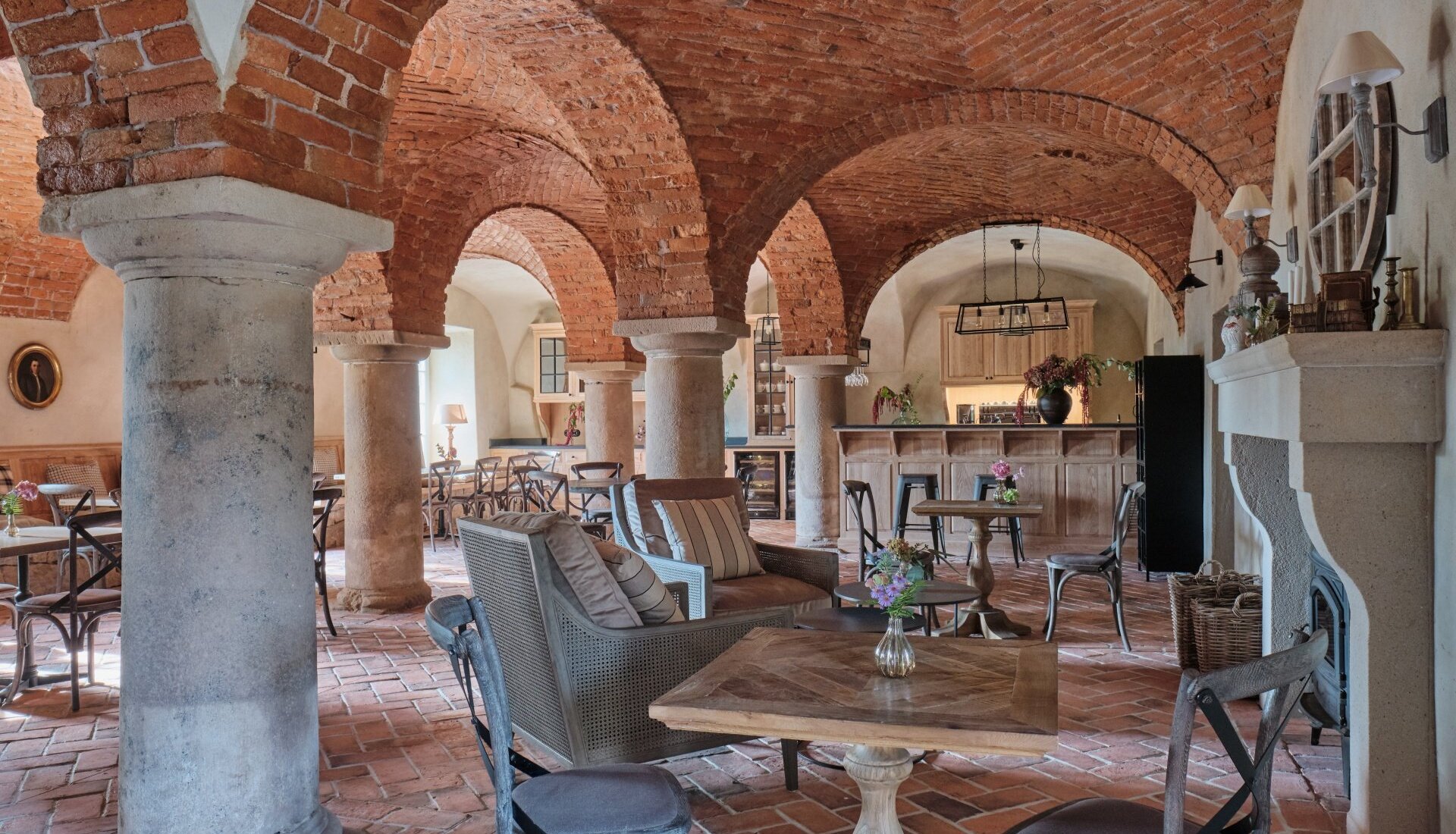 Restauracja w Pałacu Kamieniec. Ceglane łuki. Zabytkowe kolumny. Stoliki i kredensy