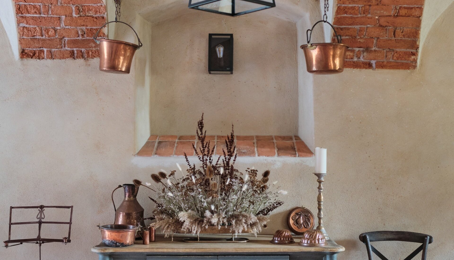 Restauracja w Pałacu Kamieniec. Ceglane łuki. zabytkowe miedziane garnki