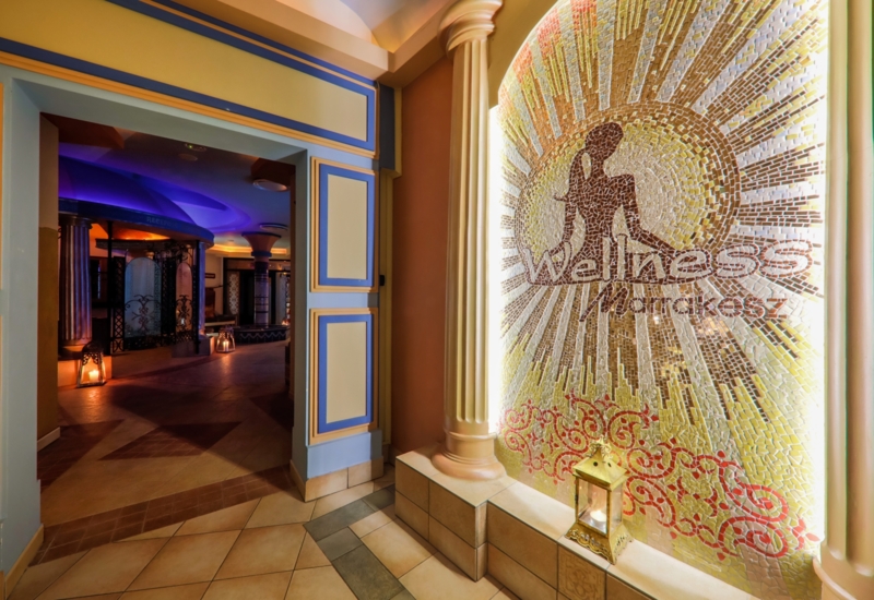 Ciepłe kolory i orientalna ściana przy wejściu do hotelowego SPA i wellness