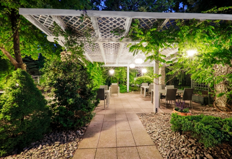 Hotelowy ogród z meblami i ciepłym, nastrojowym oświetleniem