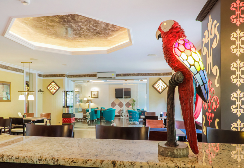 Papuga na blacie z widokiem na wnętrze restauracji hotelowej