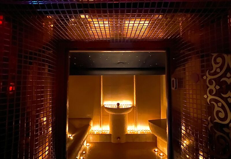 Ciemne wnętrze strefy wellness z ciepłym światłem i marokańską mozaiką