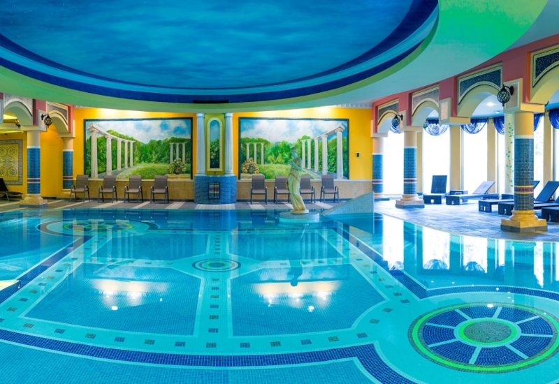 Hotelowy basen z naturalnym światłem i posągiem na środku