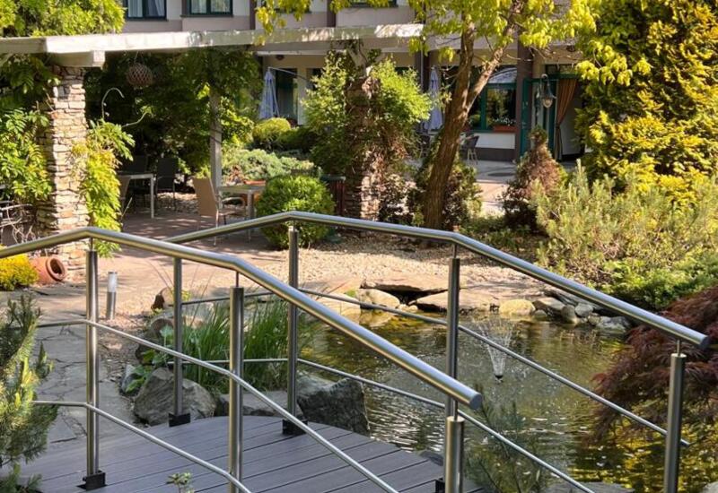 Taras z ogrodem i oczkiem wodnym przy hotelu Papuga – spokojna przestrzeń