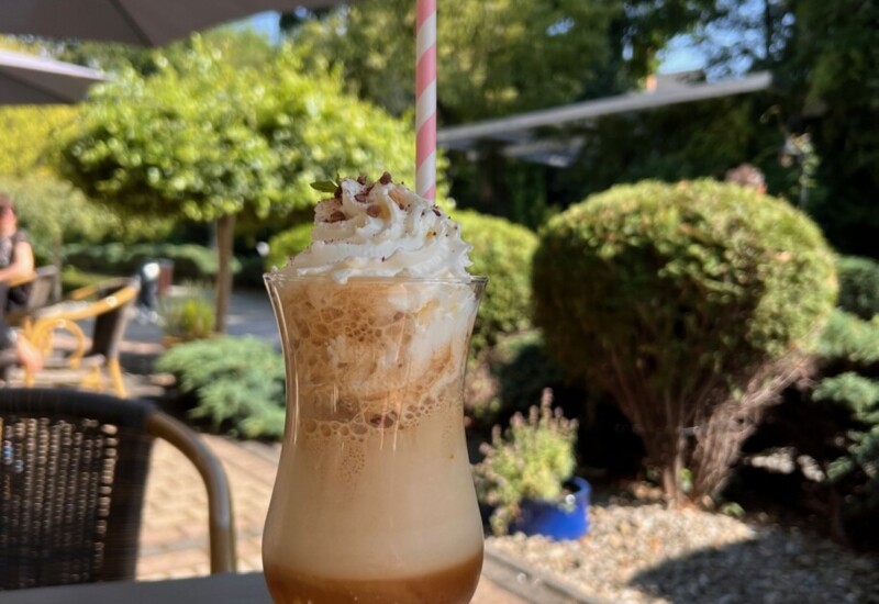 Orzeźwiająca mrożona kawa z bitą śmietaną na tarasie hotelowej kawiarni