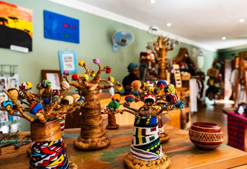 Colorful handcrafted decor and textiles displayed in a cozy hotel boutique featuring African-inspired designs and art pieces