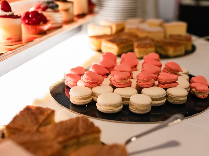 Rosa und weiße Macarons sowie Gebäck auf dem Dessertbuffet des Hotels, elegante Präsentation