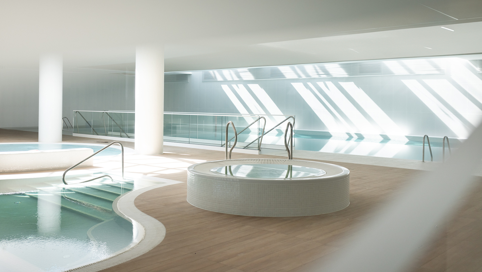 Nowoczesne spa hotelowe z jacuzzi i basenem, jasne wnętrze z dużą ilością naturalnego światła.