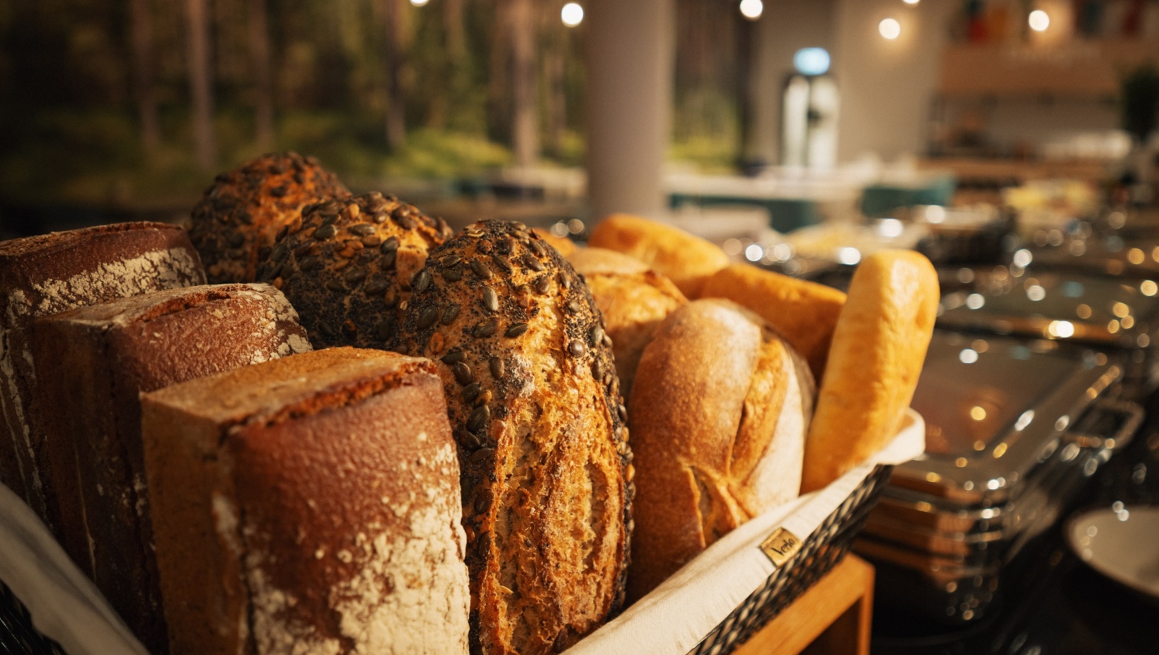 Świeże pieczywo z różnymi ziarnami serwowane w hotelowym bufecie śniadaniowym o przytulnej atmosferze.