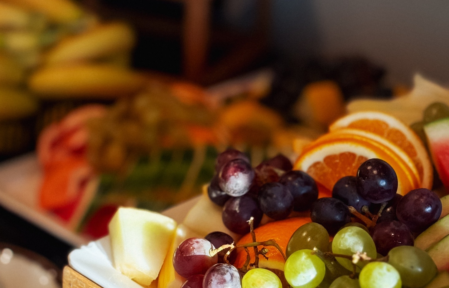 Talerz świeżych owoców z winogronami, melonem, pomarańczą i arbuzem na bufecie hotelowym