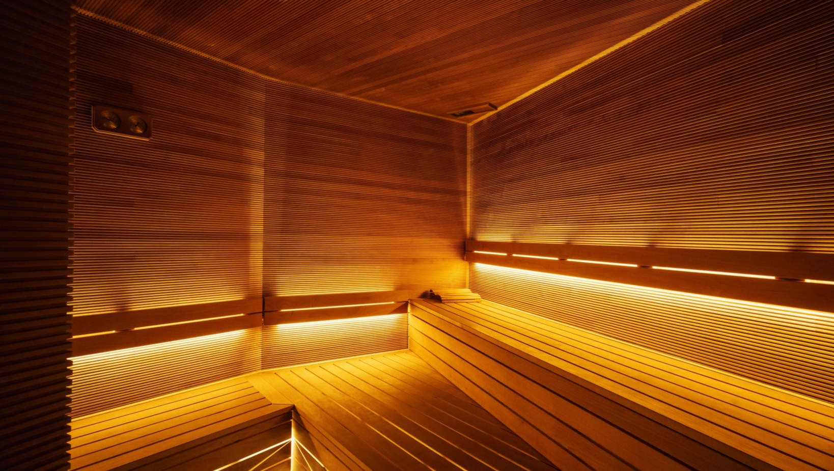 Nowoczesna sauna hotelowa z drewnianymi ławkami i ciepłym, nastrojowym oświetleniem LED