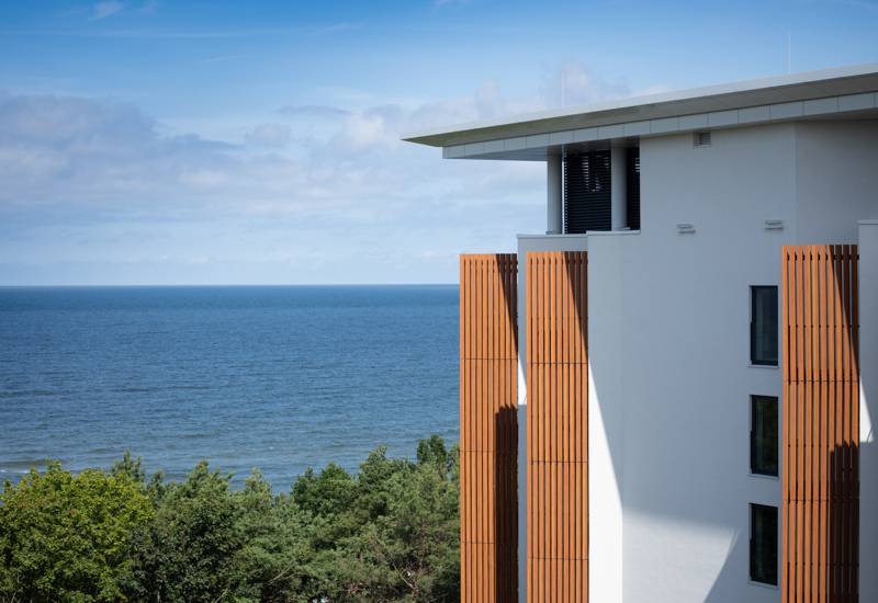 Nowoczesny hotel z drewnianymi panelami i widokiem na morze oraz zieleń sosnowych drzew