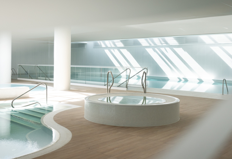 Nowoczesne spa hotelowe z jacuzzi i basenem, jasne wnętrze z dużą ilością naturalnego światła.