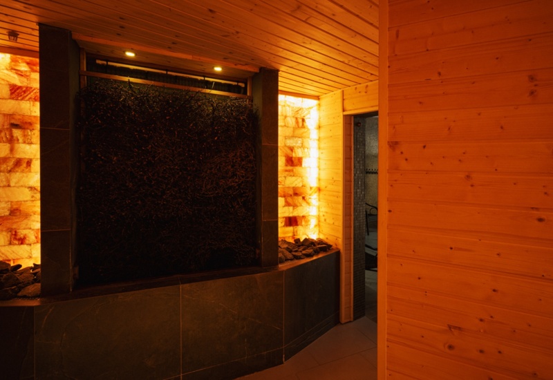 Nowoczesna sauna z drewnianymi ścianami i oświetleniem solnym tworzącym relaksującą atmosferę