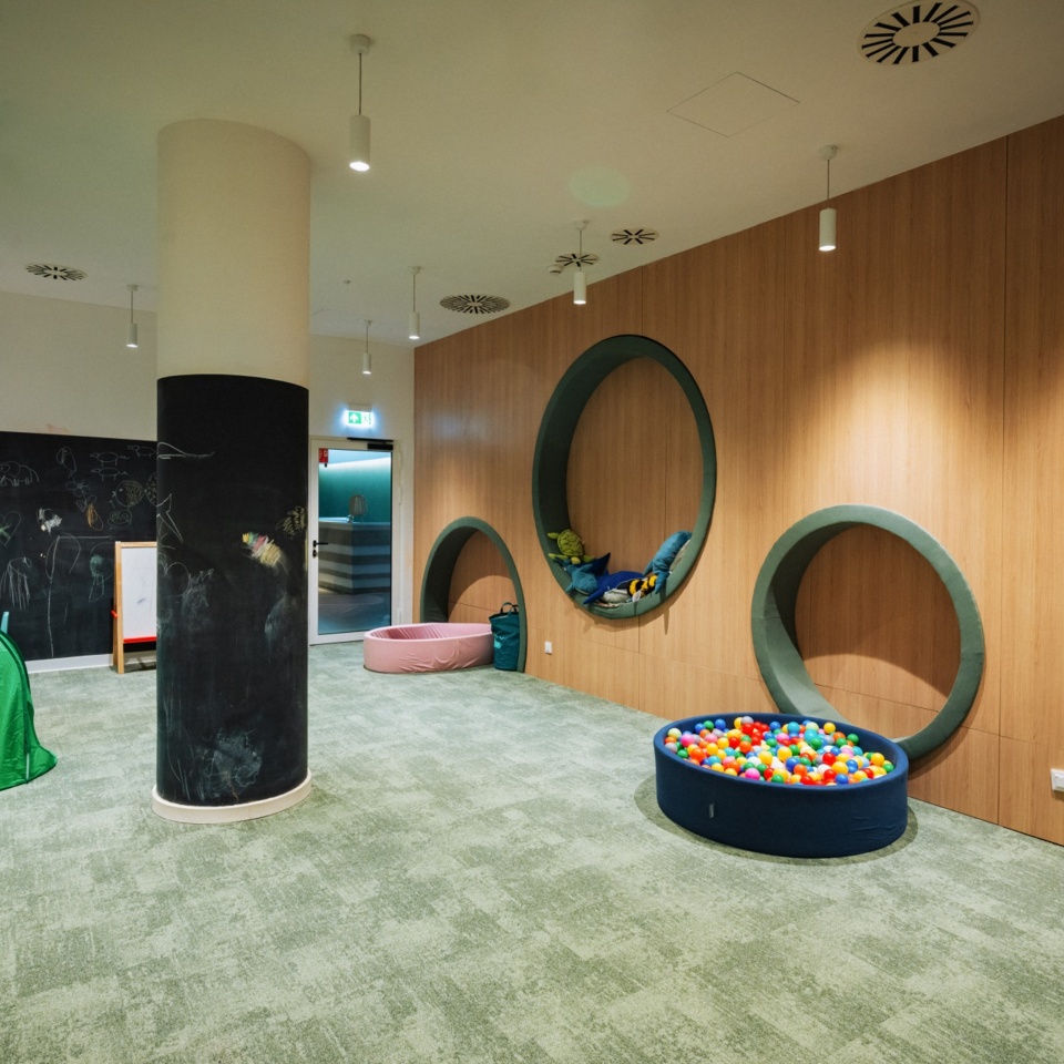 Nowoczesny kącik zabaw dla dzieci z miękkimi okrągłymi niszami, basenem z piłeczkami i zielonym namiotem