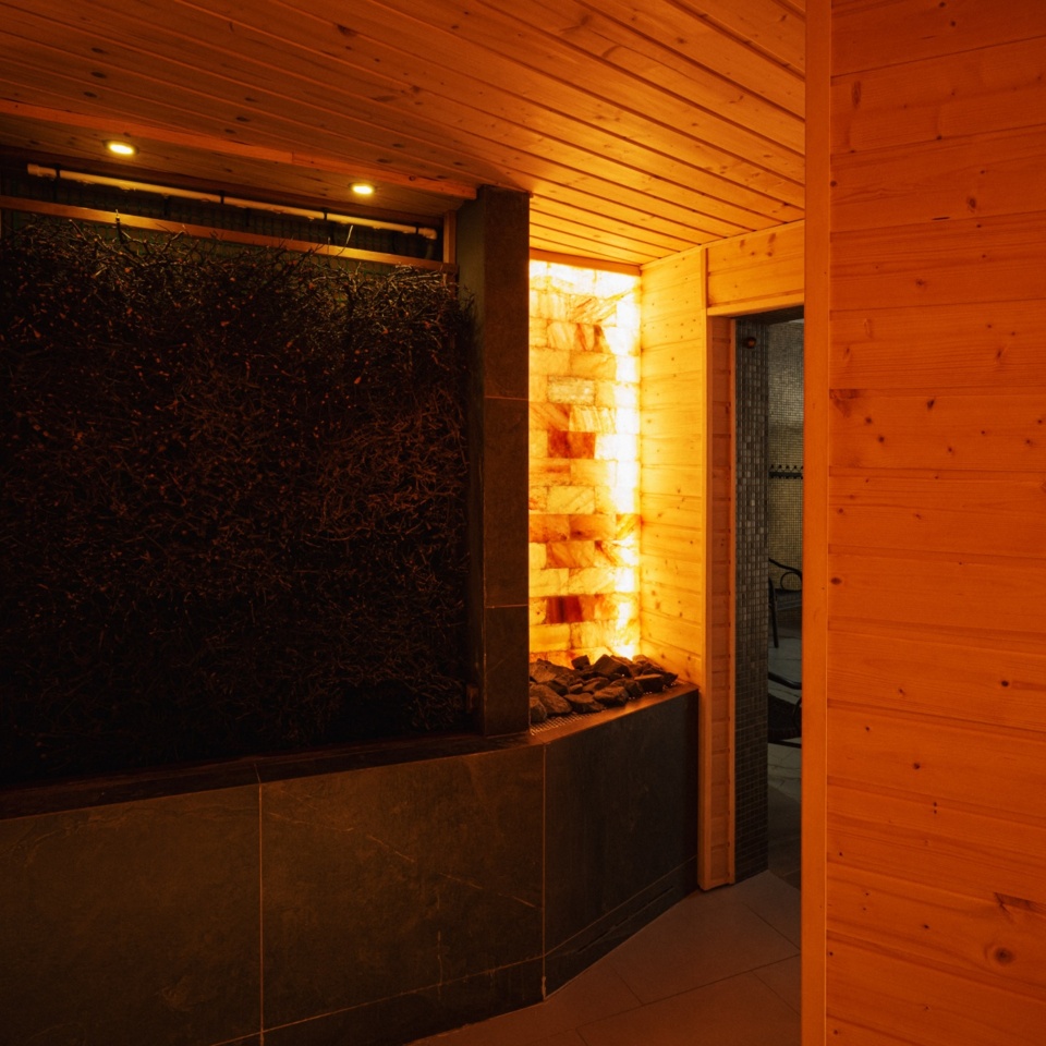 Nowoczesna sauna z drewnianymi ścianami i oświetleniem solnym tworzącym relaksującą atmosferę