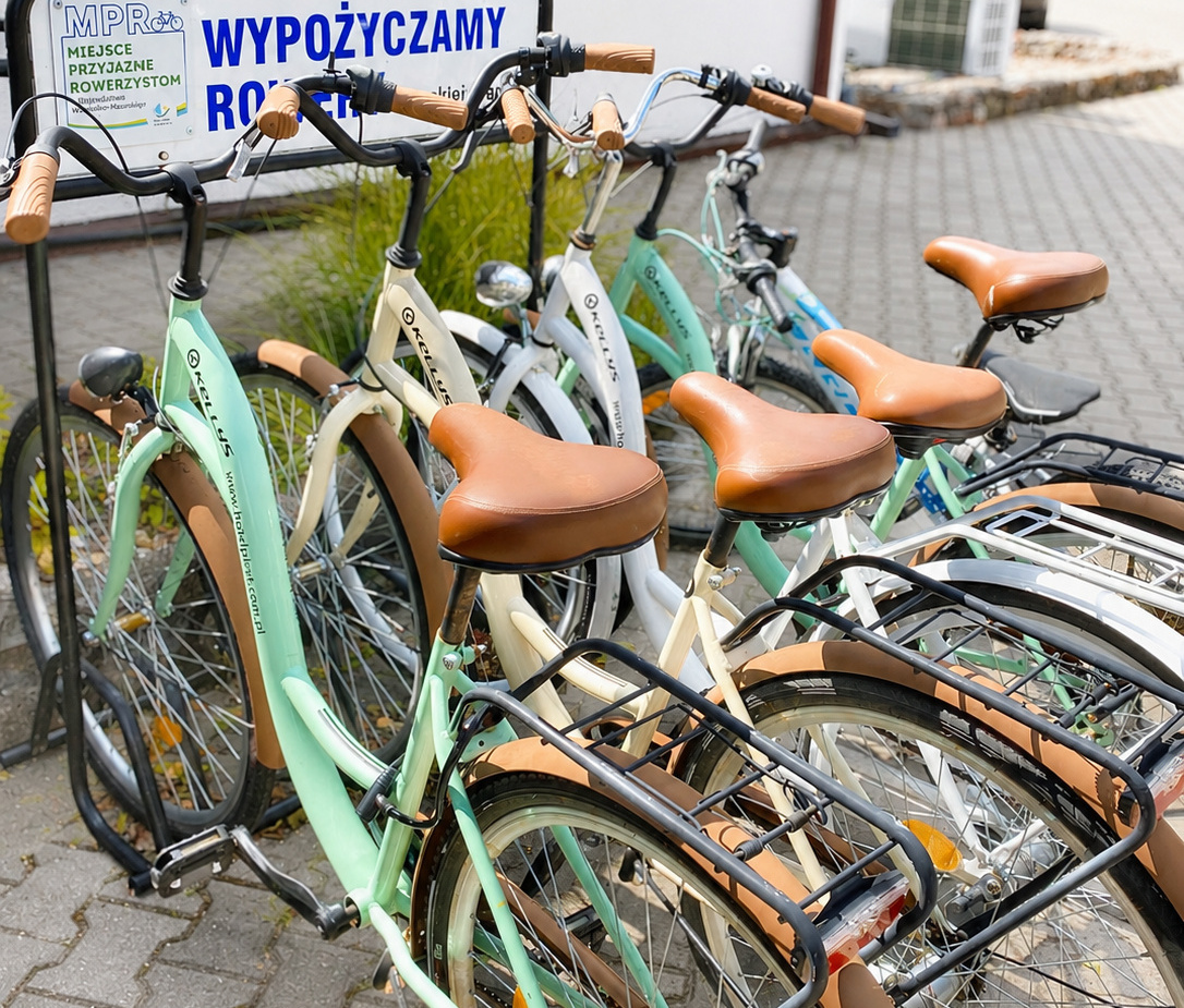 Reihe pastellfarbener Citybikes mit braunen Ledersätteln an einer Hotel-Fahrradstation – Leihfahrräder für Gäste.