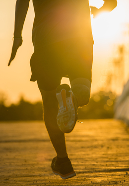 Guest jogging along a sunlit waterfront promenade at sunrise, outdoor running route with golden views