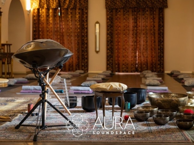 Meditations- und Klangraum mit Handpan, Klangschalen, Bodenkissen, gemusterten Teppichen und warmem Licht
