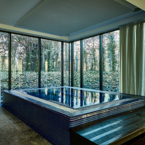 파란 모자이크 타일의 실내 자쿠지, 나무 계단과 통유리창으로 숲 정원이 보이는 스파 공간