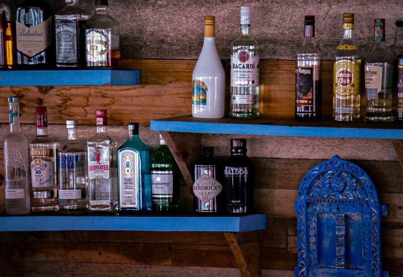 Rustic wooden shelves stocked with a variety of premium liquors and spirits, highlighting a well-equipped hotel bar area.