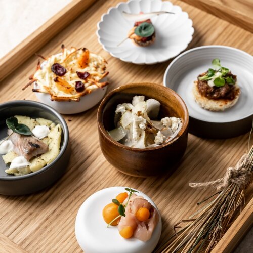 Małe porcje jedzenia na okrągłych talerzykach.