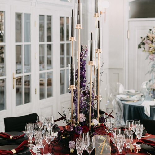 Stół udekorowany w ciemnym czerwonym kolorze.