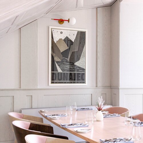 Widok na stół i plakat wiszący na ścianie.