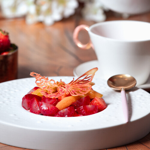 Eleganckie danie w kolorze czerwonym w dużym głębokim białym talerzu.