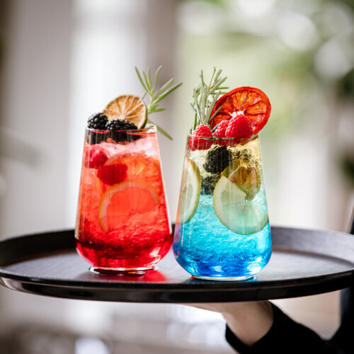 Dwa kolorowe drinki na tacy.