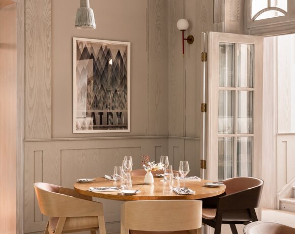 Widok na jasny okrągły stół z czterema krzesłami w jasnym pomieszczeniu.