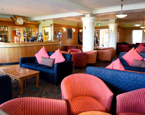 Cozy hotel lounge with bar and games room area serving bar snacks