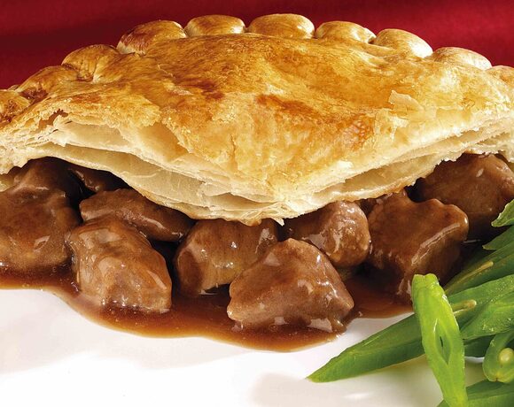 Golden puff-pastry beef pie with rich brown gravy, tender meat chunks and sautéed green beans
