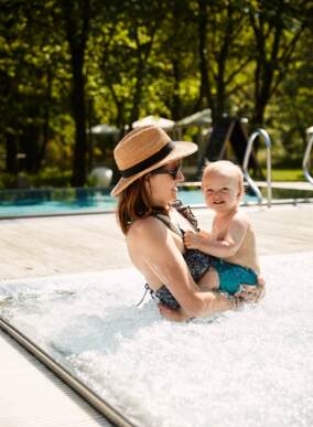 mother with a baby in the hotel pool