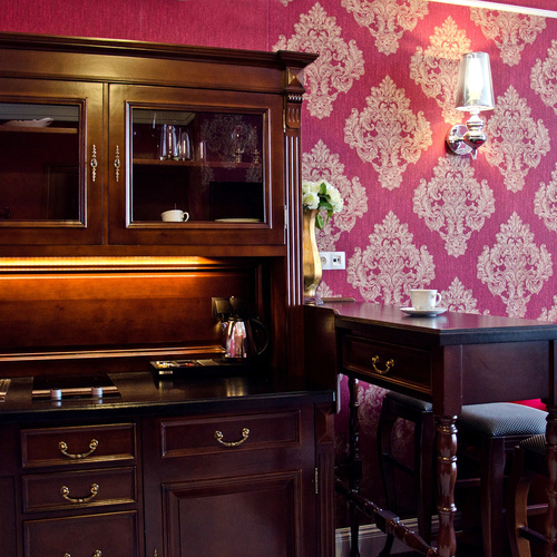 Kitchenette with dark wooden cabinetry, worktop, sink and seating area in Junior Suite Deluxe Red