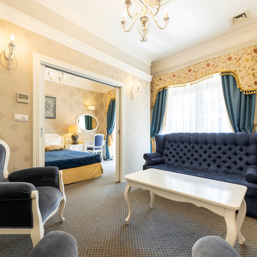Living room with a navy-blue sofa and access to a separate bedroom in Junior Suite Deluxe Blue at SleepWalker Boutique Suites in Wrocław