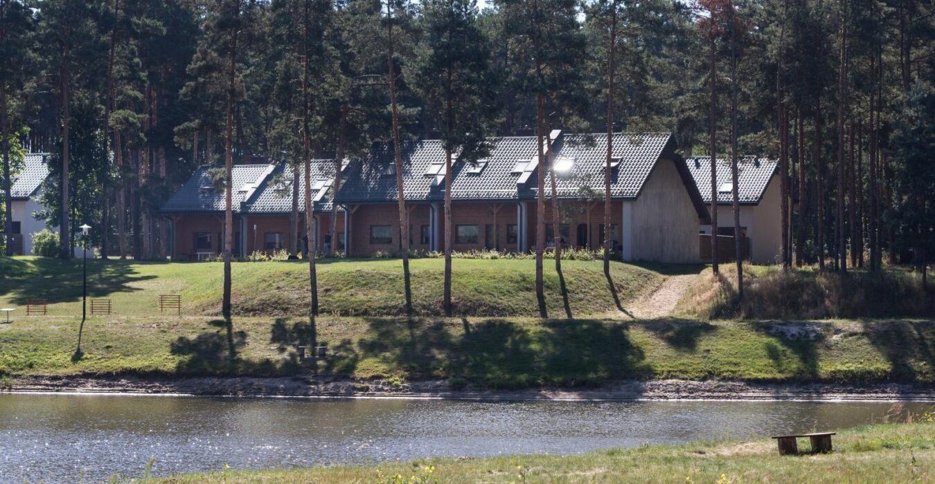 Całoroczne apartamenty z tarasami z widokiem na staw i rzekę Wartę, otoczone sosnowym lasem, idealne na wypoczynek w naturze.