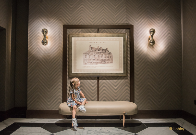 a girl looking at the picture of Stock Exchange, hotel interior