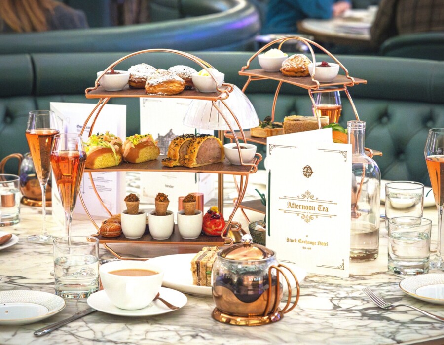 afternoon tea table, menu, tea pot, crossaints, sandwiches, desserts