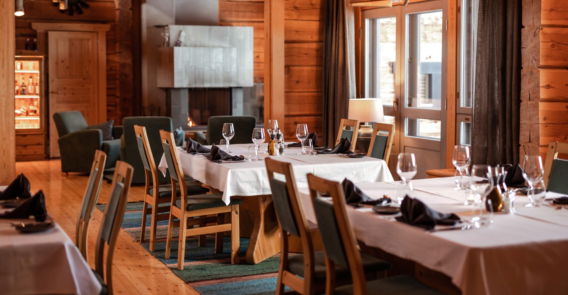 Restaurant Aihki dining room. 4-person tables with white tablecloths and wine glasses on them.
