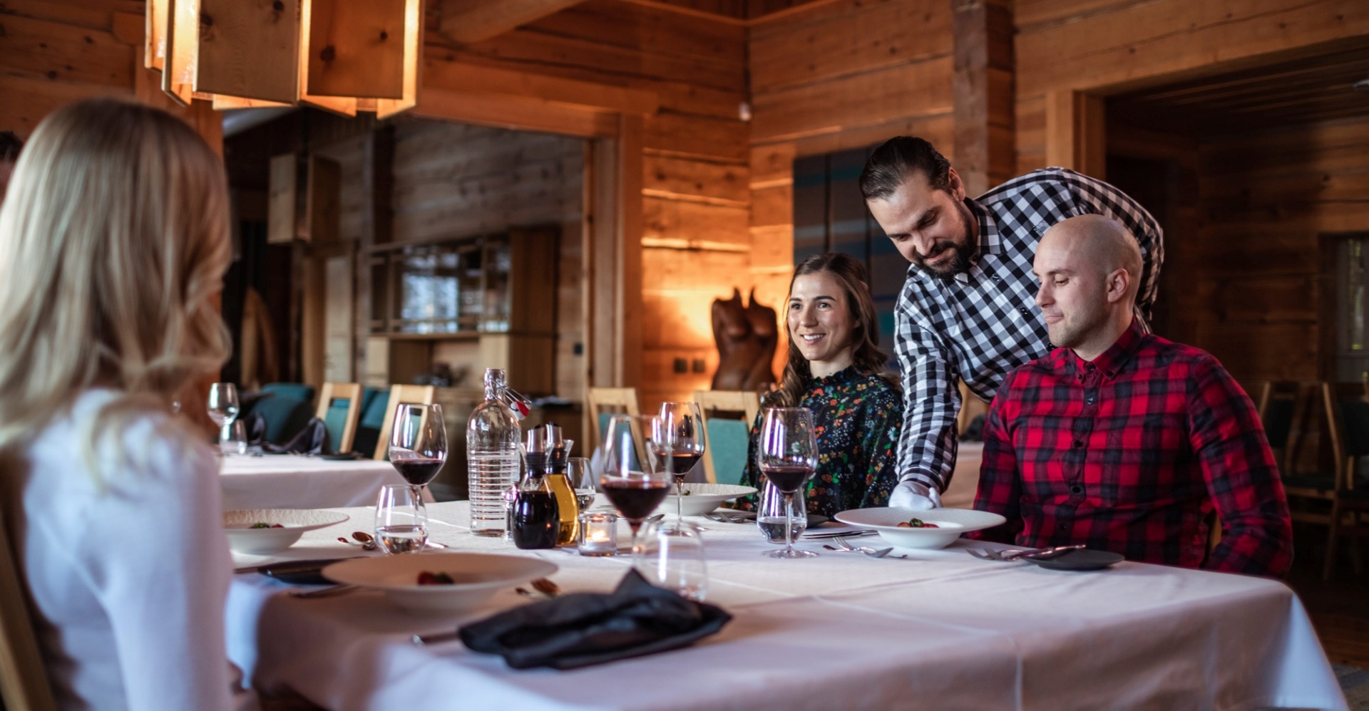 Patrons enjoying their meals and a glass of red wine at Restaurant Aihki.