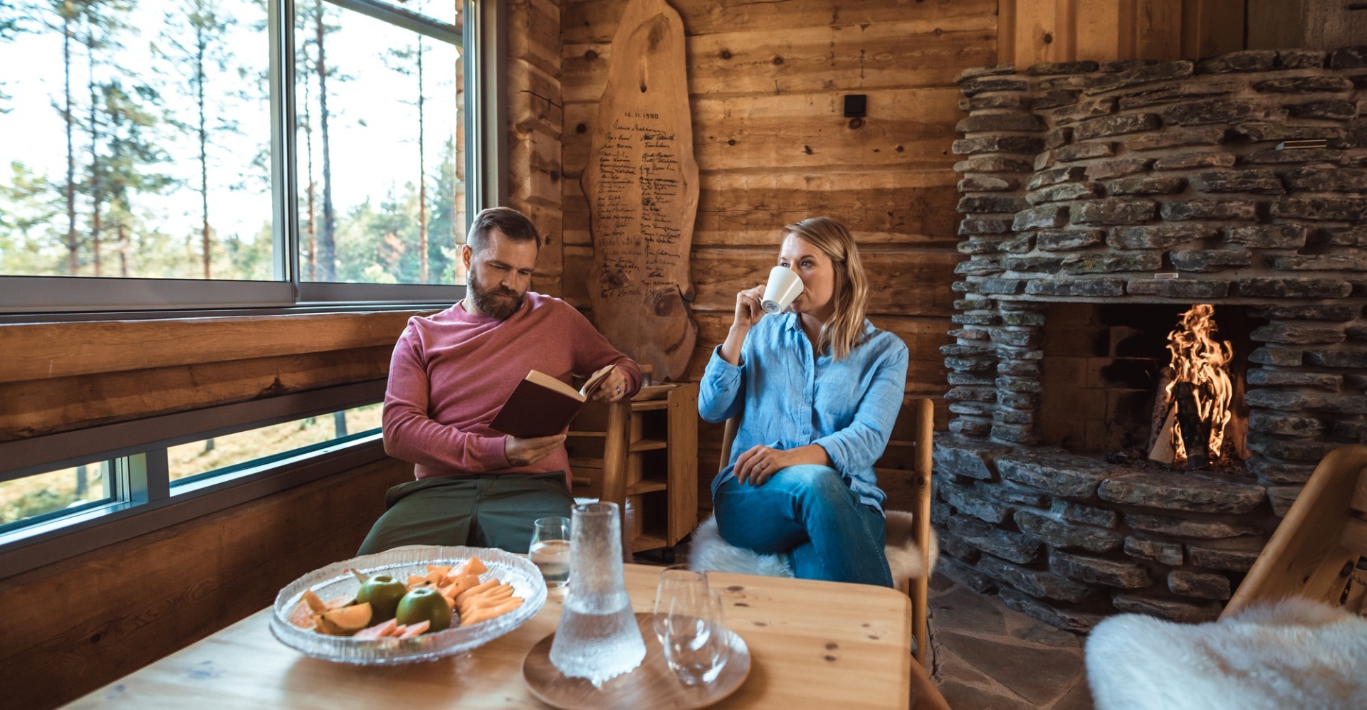 A couple enjoying lunch in a wooden lodge.