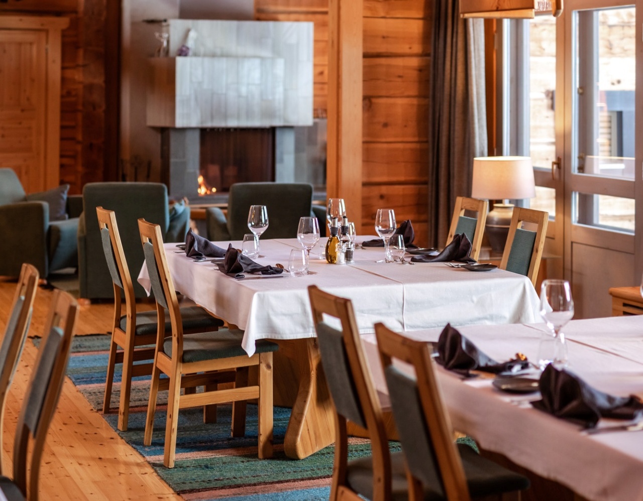 A kitchen with lined-up tables, dressed in white tablecloth.