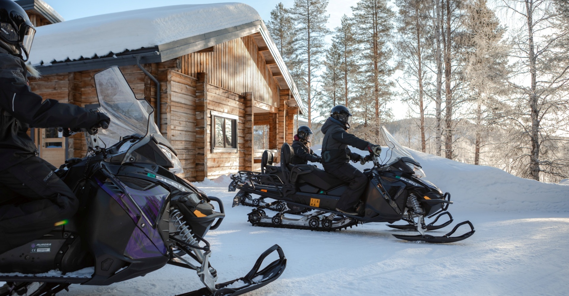 People on electric snowmobiles getting ready for a snow safari.